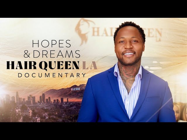 Load video: Man in a blue suit standing in front of a promotional poster for 'Hopes &amp; Dreams Hair Queen LA Documentary'.
